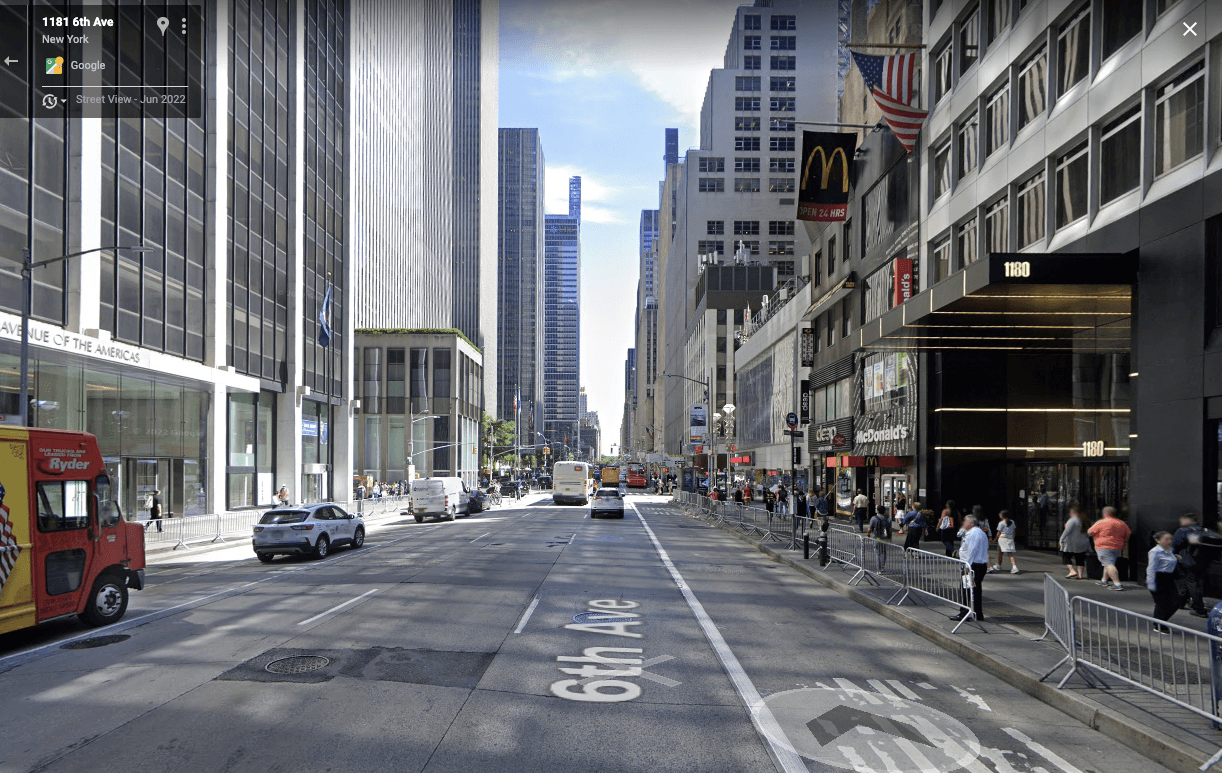 뉴욕 6th Avenue. 건물에 1180이 크게 표시되어 있고, 건물 외벽에 AVENUE OF THE AMERICAS가 새겨져 있다.